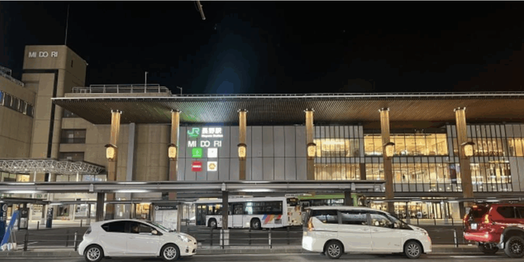夜の長野駅前、バスと車が停車している様子。